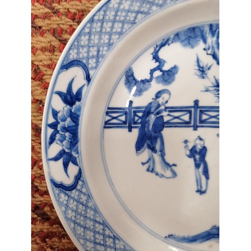 320 - A CHINESE KANGXI  (1654 - 1722) PERIOD BLUE AND WHITE PLATE DECORATED IN UNDERGLAZE WITH SCENES OF T... 