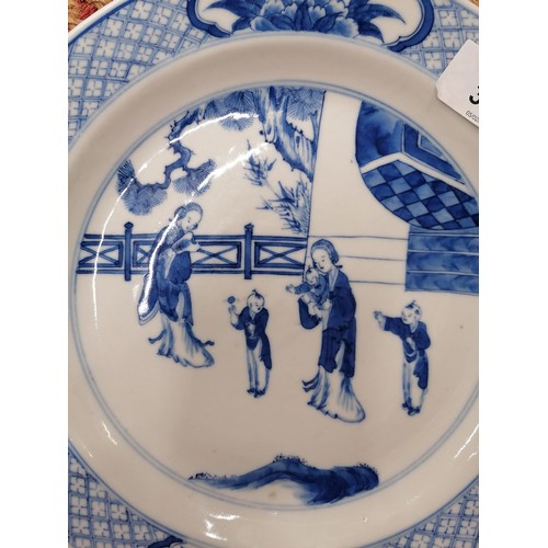 320 - A CHINESE KANGXI  (1654 - 1722) PERIOD BLUE AND WHITE PLATE DECORATED IN UNDERGLAZE WITH SCENES OF T... 