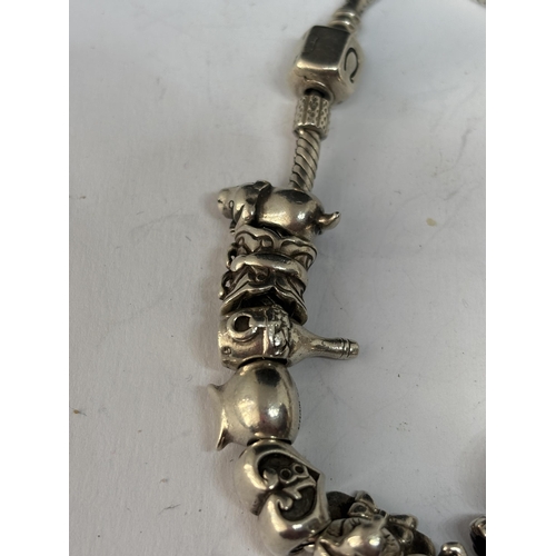 572 - A MARKED SILVER PANDORA STYLE BRACELET WITH SEVENTEEN CHARMS