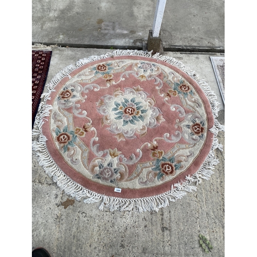 2490 - A SMALL PINK PATTERNED CIRCULAR FRINGED RUG