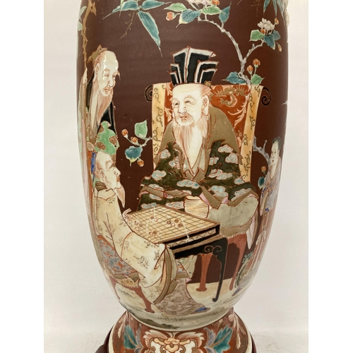 43 - A LARGE ORIENTAL VASE DECORATED WITH ELDERS SIGNING A SCROLL ON A WOODEN BASE - A/F, HEIGHT 61CM