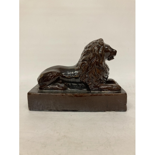 53 - A LARGE VINTAGE TREACLE GLAZED POTTERY LION ON A PLINTH, HEIGHT 24CM, LENGTH 32CM, DEPTH 15CM