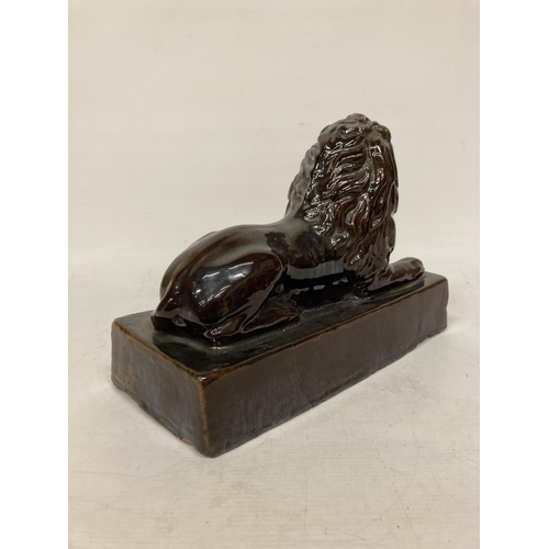 53 - A LARGE VINTAGE TREACLE GLAZED POTTERY LION ON A PLINTH, HEIGHT 24CM, LENGTH 32CM, DEPTH 15CM