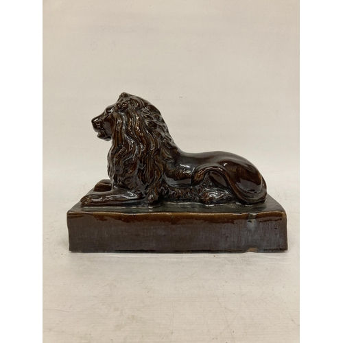 53 - A LARGE VINTAGE TREACLE GLAZED POTTERY LION ON A PLINTH, HEIGHT 24CM, LENGTH 32CM, DEPTH 15CM