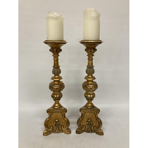 63 - A PAIR OF LARGE, HEAVY WOODEN CANDLESTICKS, ROCOCO STYLE WITH A GILT FINISH, HEIGHT 46CM