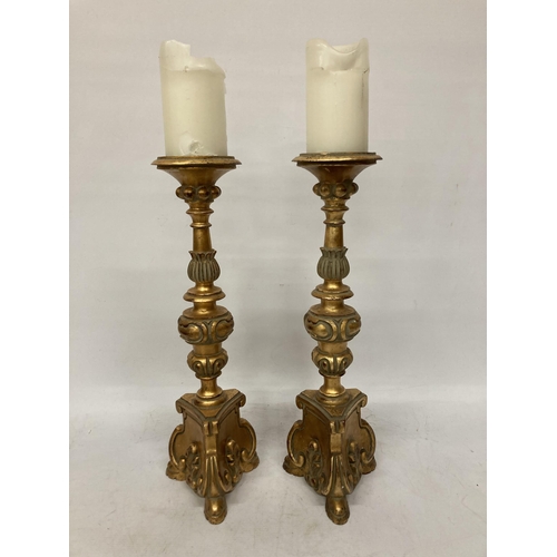 63 - A PAIR OF LARGE, HEAVY WOODEN CANDLESTICKS, ROCOCO STYLE WITH A GILT FINISH, HEIGHT 46CM