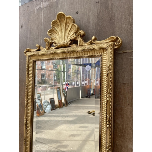 3048 - A GILT FRAMED BEVEL EDGE WALL MIRROR WITH TOP RAIL SHELL DECORATION, 53