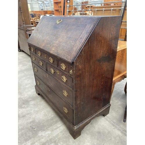 3169 - A GEORGE III OAK BUREAU WITH FITTED INTERIOR AND SEVEN DRAWERS TO BASE ON BRACKET FEET 36