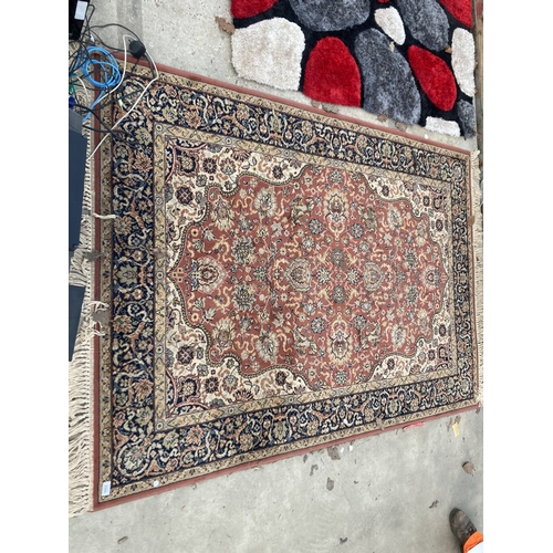 2500 - A RED PATTERNED FRINGED RUG