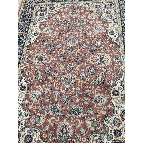 2500 - A RED PATTERNED FRINGED RUG