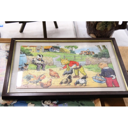 424 - A COLLECTION OF RUPERT THE BEAR ITEMS TO INCLUDE CUPS, A CERAMIC WALL CLOCK, EGG CUPS, TWO FRAMED JI... 