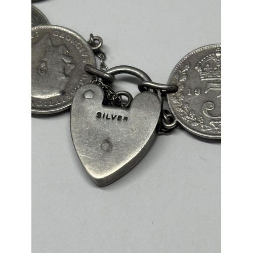  A SILVER BRACELET WITH TEN SILVER JOEYS AND A HEAT PADLOCK