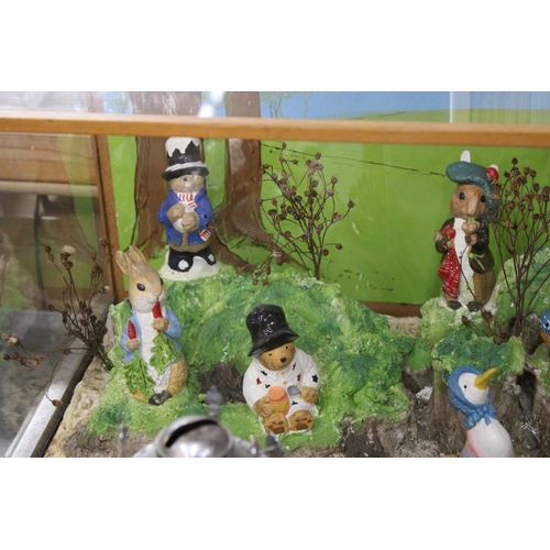 413 - A PLASTERCASTERS DISPLAY TO INCLUDE PADDINGTON BEAR AND BEATRIX POTTER FIGURES IN A LARGE GLASS DISP... 