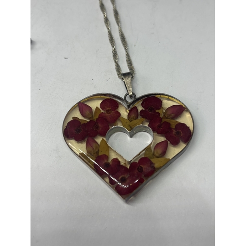 587 - A SILVER MOUNTED HEART PENDANT ON A SILVER CHAIN