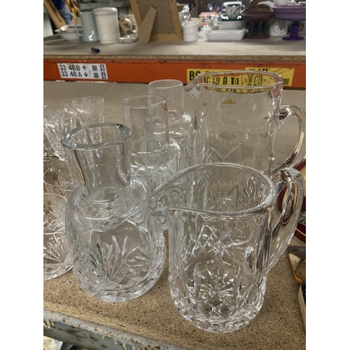 863 - A LARGE QUANTITY OF GLASSWARE TO INCLUDE WATER CARAFES, CHAMPAGNE FLUTES, WINE, TUMBLERS, ETC