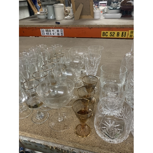 863 - A LARGE QUANTITY OF GLASSWARE TO INCLUDE WATER CARAFES, CHAMPAGNE FLUTES, WINE, TUMBLERS, ETC