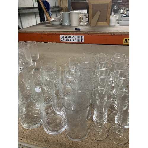 863 - A LARGE QUANTITY OF GLASSWARE TO INCLUDE WATER CARAFES, CHAMPAGNE FLUTES, WINE, TUMBLERS, ETC