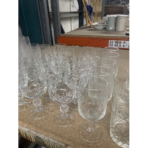 863 - A LARGE QUANTITY OF GLASSWARE TO INCLUDE WATER CARAFES, CHAMPAGNE FLUTES, WINE, TUMBLERS, ETC