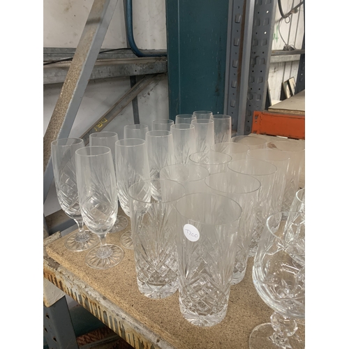 863 - A LARGE QUANTITY OF GLASSWARE TO INCLUDE WATER CARAFES, CHAMPAGNE FLUTES, WINE, TUMBLERS, ETC