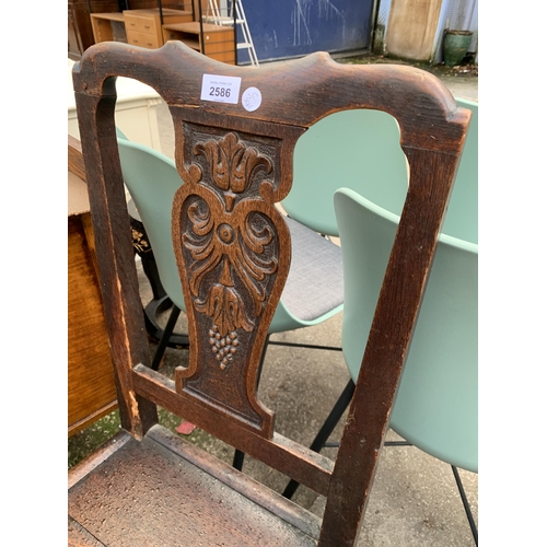 2586 - AN 18TH CENTURY OAK DINING CHAIR WITH CARVED FOLIATE BACK PANEL