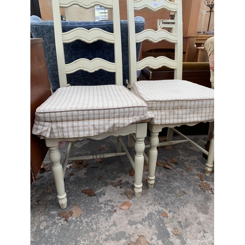 2738 - A PAIR OF CREAM PAINTED LADDER BACK CHAIRS WITH RUSH SEATS AND FITTED CUSHIONS