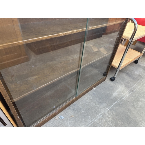 2810 - AN OAK PHOENIX HOUSE LTD BOOKCASE WITH TWO GLASS SLIDING DOORS AND A C.D. RACK