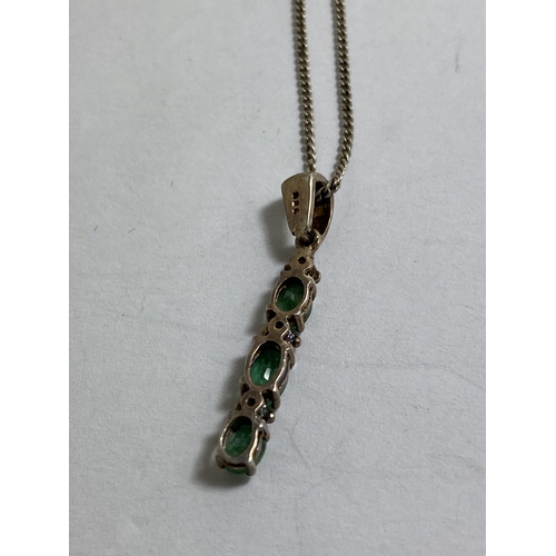 652 - A MARKED SILVER NECKLACE WITH AN EMERALD PENDANT WITH THREE STONES