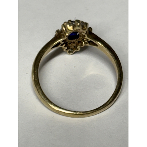 521 - A MARKED 9 CARAT GOLD RING WITH A CENTRE SAPPHIRE SURROUNDED BY DIAMONDS SIZE N