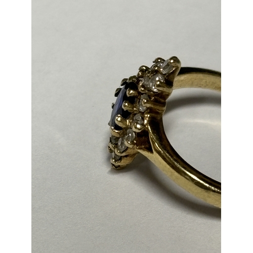 521 - A MARKED 9 CARAT GOLD RING WITH A CENTRE SAPPHIRE SURROUNDED BY DIAMONDS SIZE N