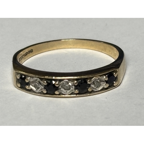 523 - A MARKED 9 CARAT GOLD RING WITH FOUR IN LINE SAPPHIRES AND THREE DIAMONDS SIZE O/P