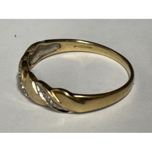 526 - A MARKED 9 CARAT GOLD RING WITH THREE LINES OF DIAMONDS ON A TWIST DESIGN SIZE R