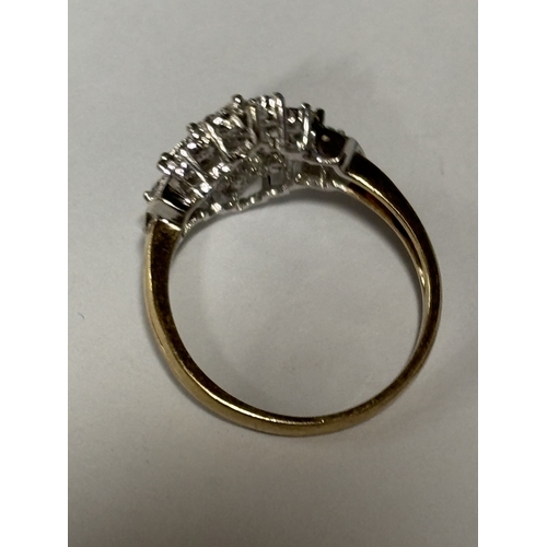 527 - A MARKED 9 CARAT GOLD RING WITH DIAMONDS IN A DECORATIVE CLUSTER DESIGN