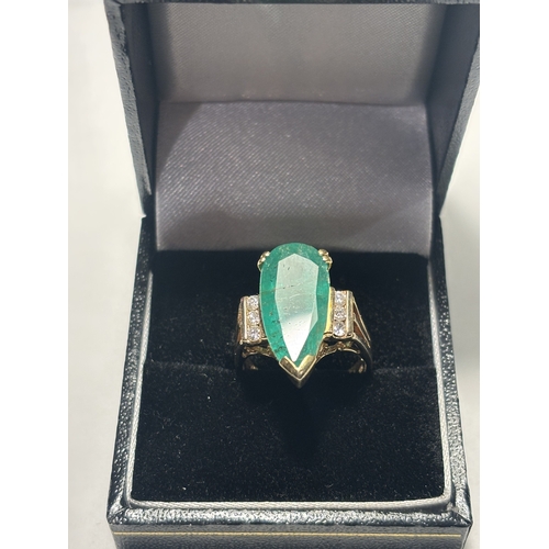 528 - A MARKED 14 CARAT GOLD RING WITH LARGE TEARDROP SHAPED EMERALD WITH DIAMONDS TO EACH SIDE SIZE N/O I... 