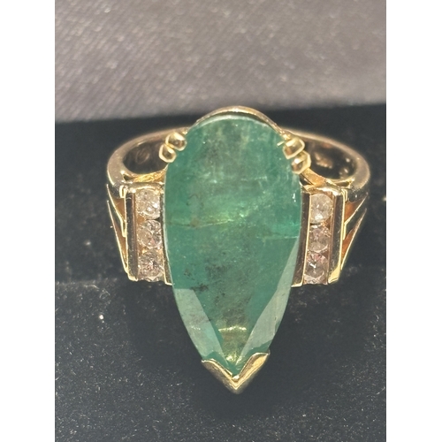 528 - A MARKED 14 CARAT GOLD RING WITH LARGE TEARDROP SHAPED EMERALD WITH DIAMONDS TO EACH SIDE SIZE N/O I... 