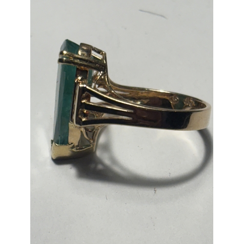 528 - A MARKED 14 CARAT GOLD RING WITH LARGE TEARDROP SHAPED EMERALD WITH DIAMONDS TO EACH SIDE SIZE N/O I... 