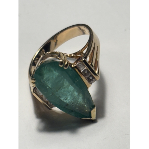 528 - A MARKED 14 CARAT GOLD RING WITH LARGE TEARDROP SHAPED EMERALD WITH DIAMONDS TO EACH SIDE SIZE N/O I... 