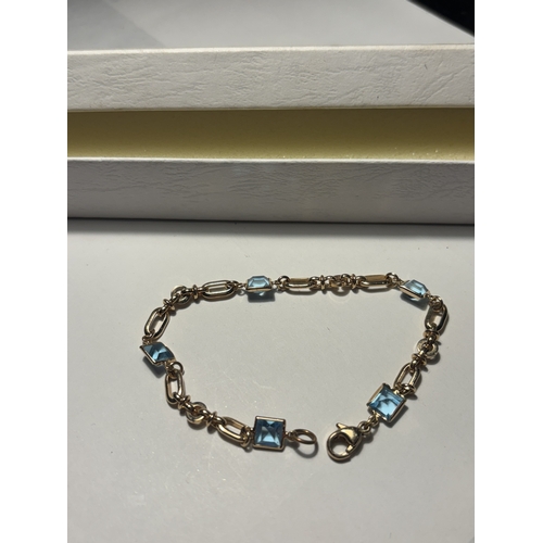 542 - A TESTED TO 9 CARAT GOLD AND POSSIBLY AQUAMARINE BRACELET IN A PRESENTATION BOX