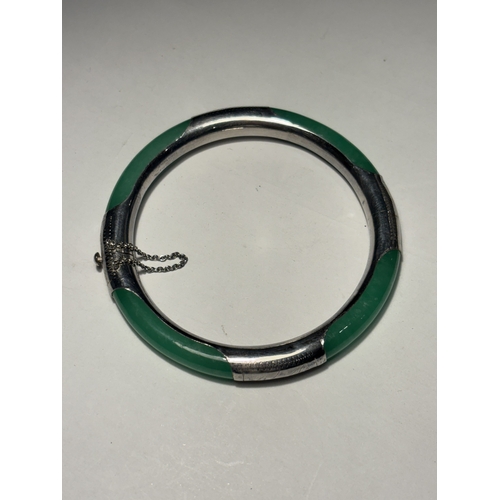 544 - AN APPLE JADE AND CHASED SILVER BANGLE, 2.5 INCHES IN A PRESENTATION BOX