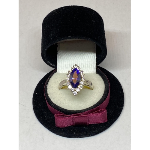 551 - A MARKED SILVER DRESS RING WITH AN AMETHYST COLOURED STONE SURROUNDED BY CLEAR STONES IN A PRESENTAT... 