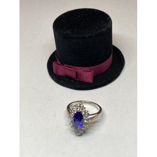 551 - A MARKED SILVER DRESS RING WITH AN AMETHYST COLOURED STONE SURROUNDED BY CLEAR STONES IN A PRESENTAT... 