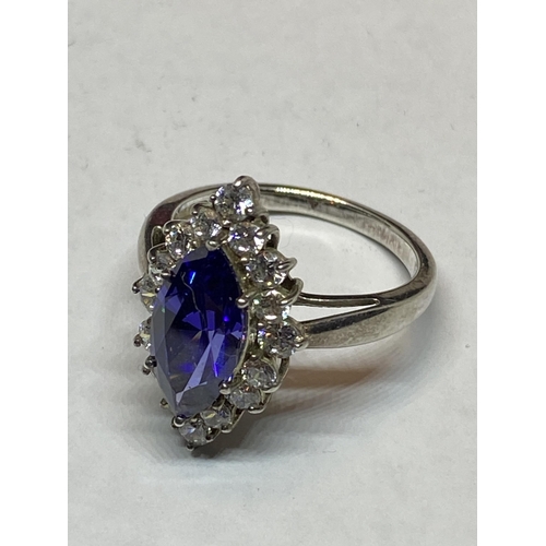 551 - A MARKED SILVER DRESS RING WITH AN AMETHYST COLOURED STONE SURROUNDED BY CLEAR STONES IN A PRESENTAT... 