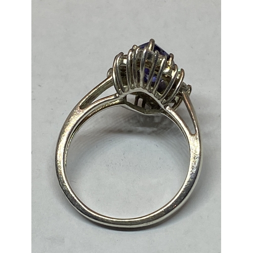 551 - A MARKED SILVER DRESS RING WITH AN AMETHYST COLOURED STONE SURROUNDED BY CLEAR STONES IN A PRESENTAT... 