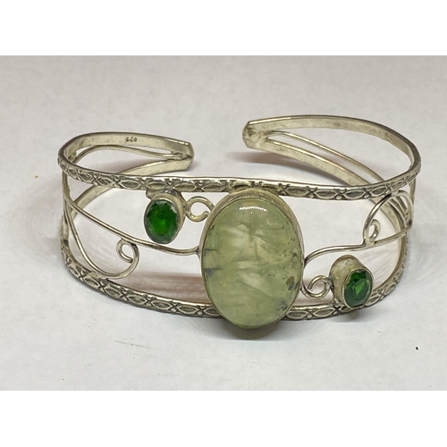 557 - A MARKED SILVER BANGLE WITH THREE STONES