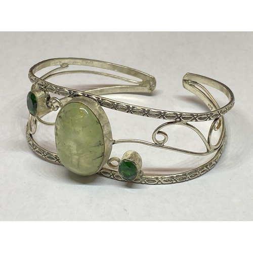 557 - A MARKED SILVER BANGLE WITH THREE STONES