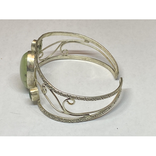 557 - A MARKED SILVER BANGLE WITH THREE STONES