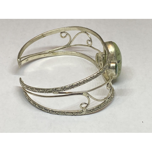 557 - A MARKED SILVER BANGLE WITH THREE STONES