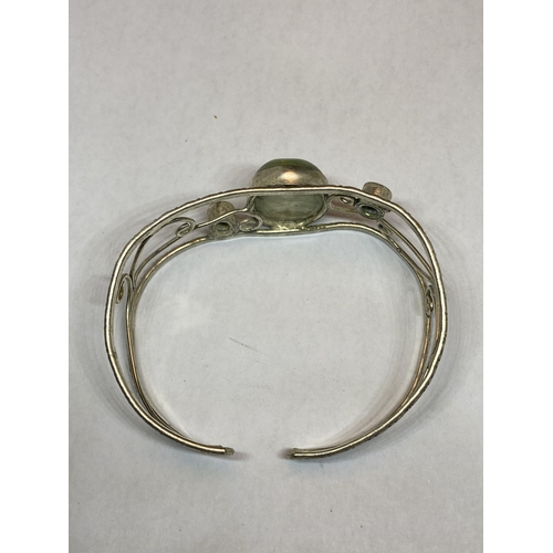 557 - A MARKED SILVER BANGLE WITH THREE STONES