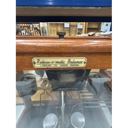 29 - A SET OF VINTAGE RELEAS-O-MATIC BALANCE SCALES IN A WOOD AND GLASS CASE, FROM L OERTLING, LONDON