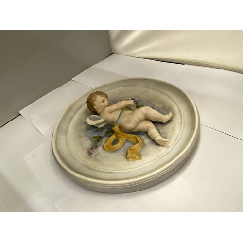 28 - A FINE ANTIQUE BISQUE POLYCHROME PORCELAIN WALL PLAQUE OF A CHERUB HOLDING GRAPES IN THE STYLE OF BA... 