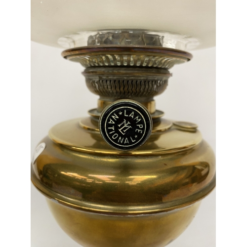 18 - A  VICTORIAN BRASS CORINTHIAN COLUMN OIL LAMP WITH A FROSTED GLASS SHADE WIH ETCHED DETAIL
